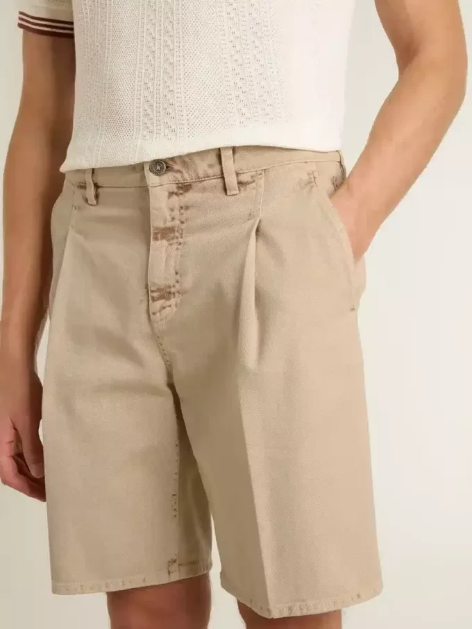Bermudas de hombre en denim beige con acabado desgastado.