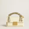 Bolso Venezia pequeño en piel color mantequilla con bufanda trenzada y doble charm. Bolso Venezia pequeño en piel color mantequilla con bufanda trenzada y doble charm.