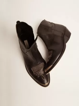 Botines juveniles de piel negra con bordados en color arena.