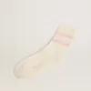 Calcetines blancos con acabado desgastado, logotipo rosa claro y rayas. Calcetines blancos con acabado desgastado, logotipo rosa claro y rayas.