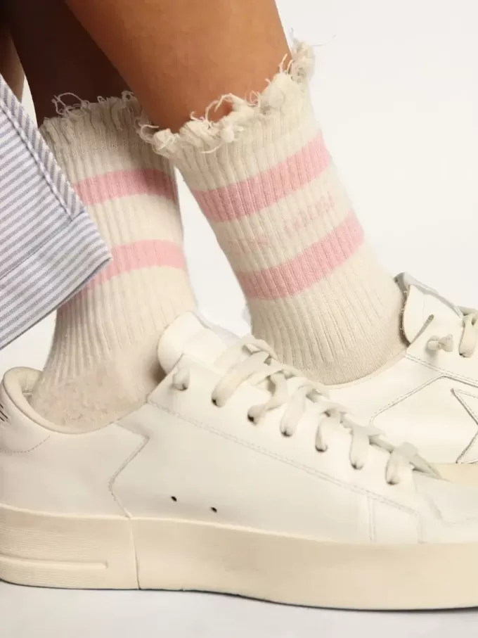 Calcetines blancos con acabado desgastado, logotipo rosa claro y rayas. Calcetines blancos con acabado desgastado, logotipo rosa claro y rayas.