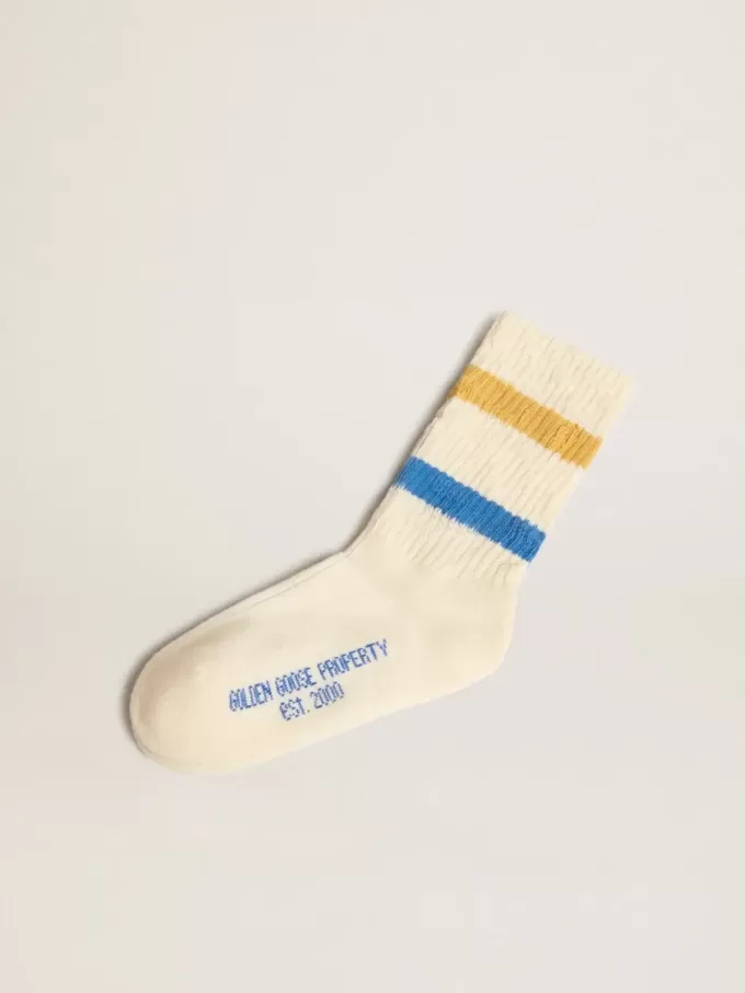 Calcetines blancos desgastados para niño con detalles desgastados y rayas bicolor en azul brillante y mostaza. Calcetines blancos desgastados para niño con detalles desgastados y rayas bicolor en azul brillante y mostaza.