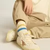 Calcetines blancos desgastados para niño con detalles desgastados y rayas bicolor en azul brillante y mostaza. Calcetines blancos desgastados para niño con detalles desgastados y rayas bicolor en azul brillante y mostaza.