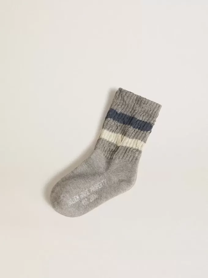 Calcetines grises para niño con detalles desgastados y rayas blancas y azules desgastadas Calcetines grises para niño con detalles desgastados y rayas blancas y azules desgastadas