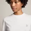 Camiseta blanca de mujer con estrella plateada brillante en la parte delantera