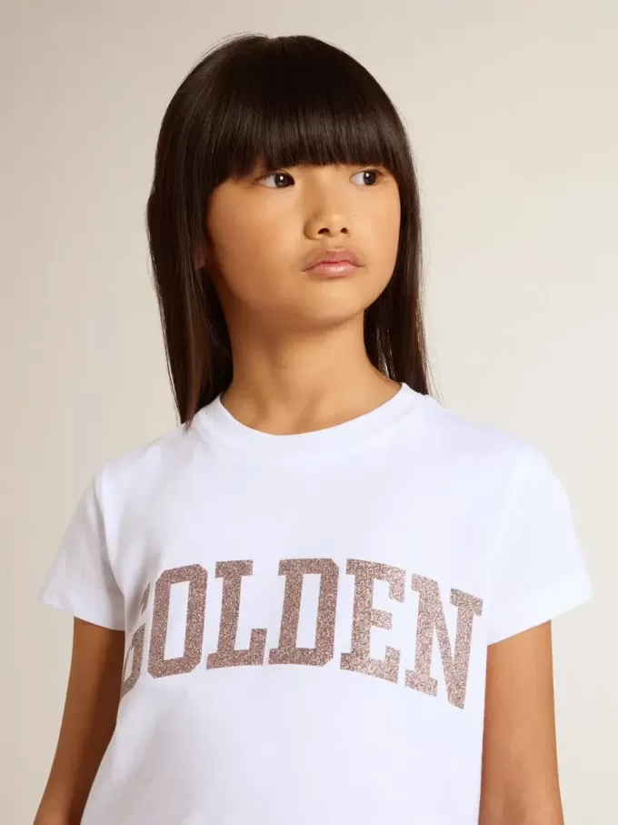 Camiseta blanca para niña con letras doradas y purpurina rosa. Camiseta blanca para niña con letras doradas y purpurina rosa.