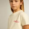 Camiseta de algodón para niña en blanco desgastado con bordado rojo en el pecho Camiseta de algodón para niña en blanco desgastado con bordado rojo en el pecho