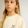 Camiseta para niña en blanco desgastado con bordado en la parte delantera y estampado en la espalda Camiseta para niña en blanco desgastado con bordado en la parte delantera y estampado en la espalda