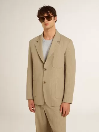 Chaqueta de hombre beige a rayas con un corte oversize y botonadura sencilla.
