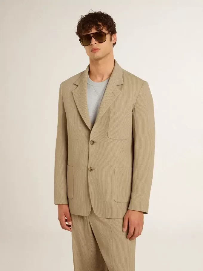 Chaqueta de hombre beige a rayas con un corte oversize y botonadura sencilla. Chaqueta de hombre beige a rayas con un corte oversize y botonadura sencilla.