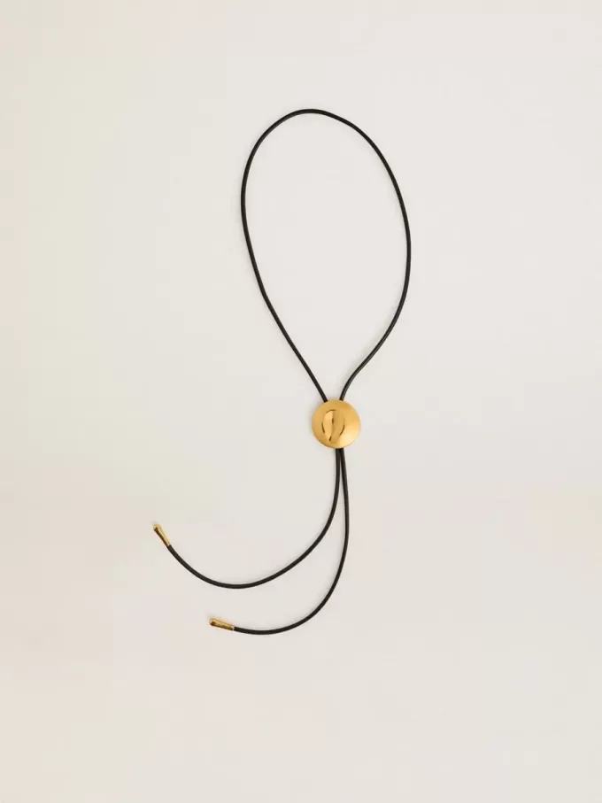 Collar bolo tie Jewelmates en cuero negro con detalles metálicos en oro antiguo Collar bolo tie Jewelmates en cuero negro con detalles metálicos en oro antiguo