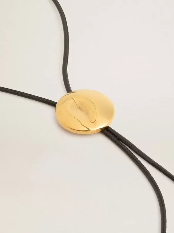 Collar bolo tie Jewelmates en cuero negro con detalles metálicos en oro antiguo Collar bolo tie Jewelmates en cuero negro con detalles metálicos en oro antiguo