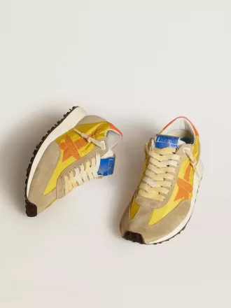 Marathon para mujer con parte superior de nailon amarillo y estrella naranja.