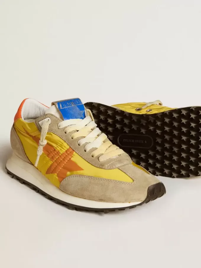 Marathon para mujer con parte superior de nailon amarillo y estrella naranja. Marathon para mujer con parte superior de nailon amarillo y estrella naranja.