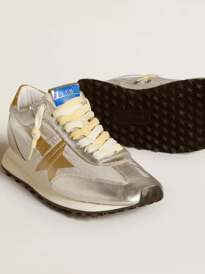 Marathon para mujer con parte superior de nailon ripstop plateado y estrella dorada. Marathon para mujer con parte superior de nailon ripstop plateado y estrella dorada.