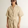 Mono de mujer en denim beige con cinturón y bajo deshilachado Mono de mujer en denim beige con cinturón y bajo deshilachado