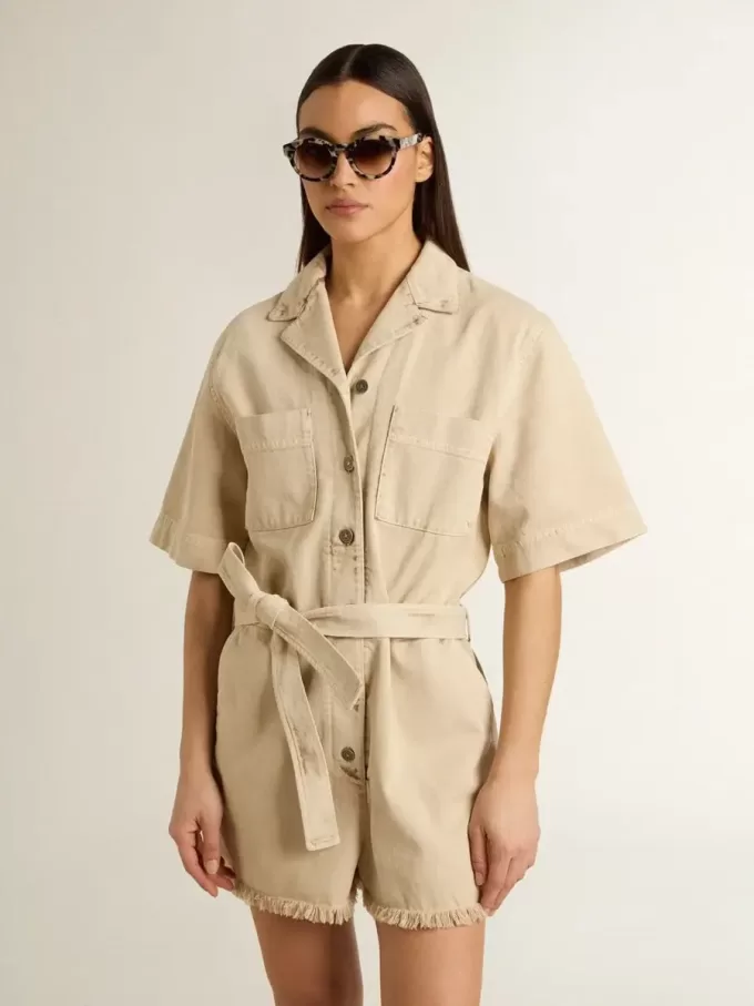 Mono de mujer en denim beige con cinturón y bajo deshilachado Mono de mujer en denim beige con cinturón y bajo deshilachado
