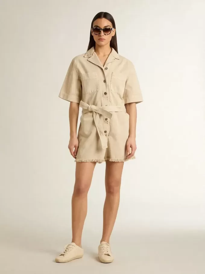 Mono de mujer en denim beige con cinturón y bajo deshilachado Mono de mujer en denim beige con cinturón y bajo deshilachado