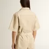 Mono de mujer en denim beige con cinturón y bajo deshilachado Mono de mujer en denim beige con cinturón y bajo deshilachado