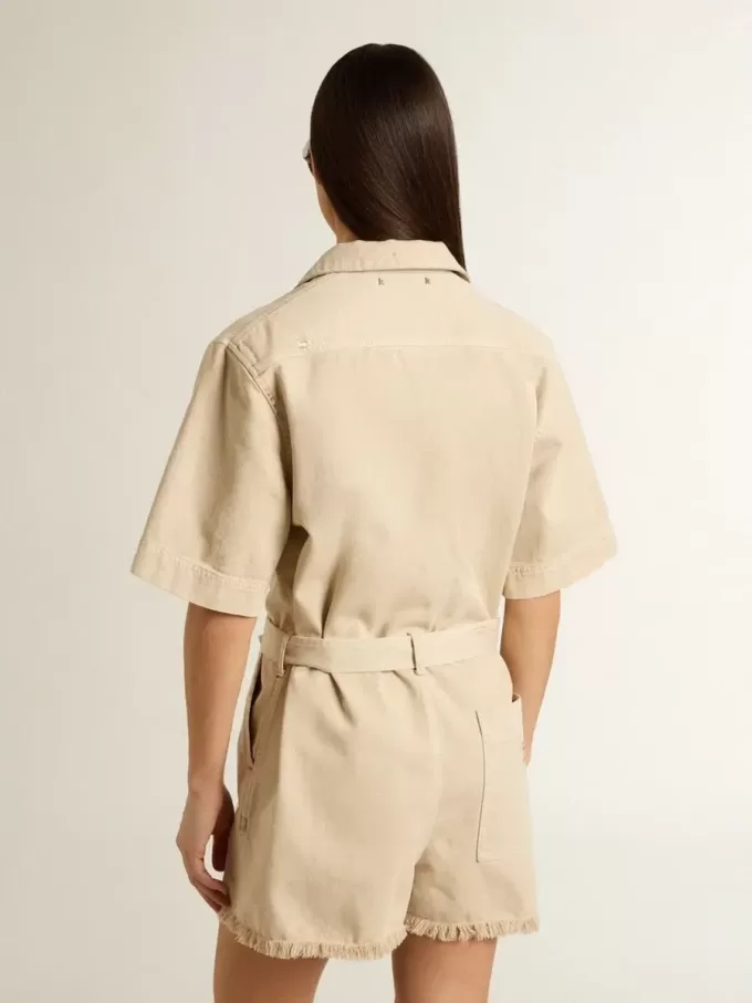 Mono de mujer en denim beige con cinturón y bajo deshilachado Mono de mujer en denim beige con cinturón y bajo deshilachado