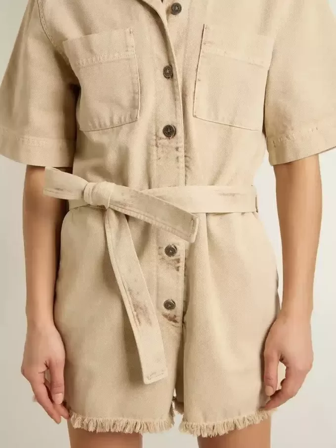 Mono de mujer en denim beige con cinturón y bajo deshilachado Mono de mujer en denim beige con cinturón y bajo deshilachado