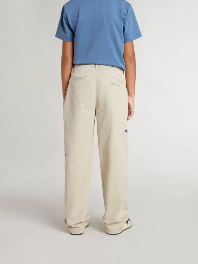 Pantalones chinos beige para niño con salpicaduras multicolores Pantalones chinos beige para niño con salpicaduras multicolores