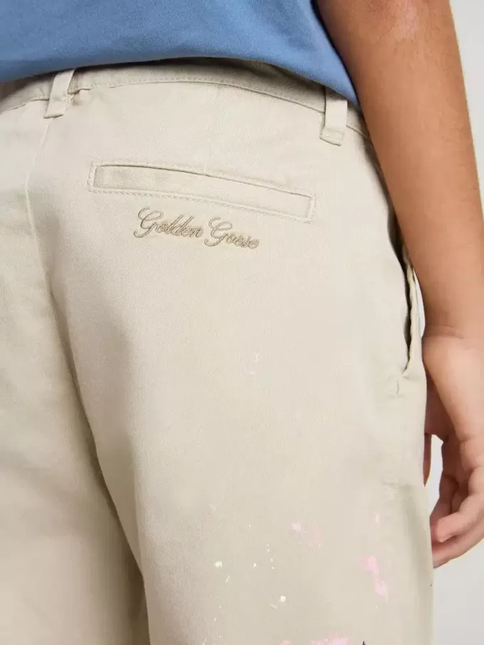 Pantalones chinos beige para niño con salpicaduras multicolores Pantalones chinos beige para niño con salpicaduras multicolores