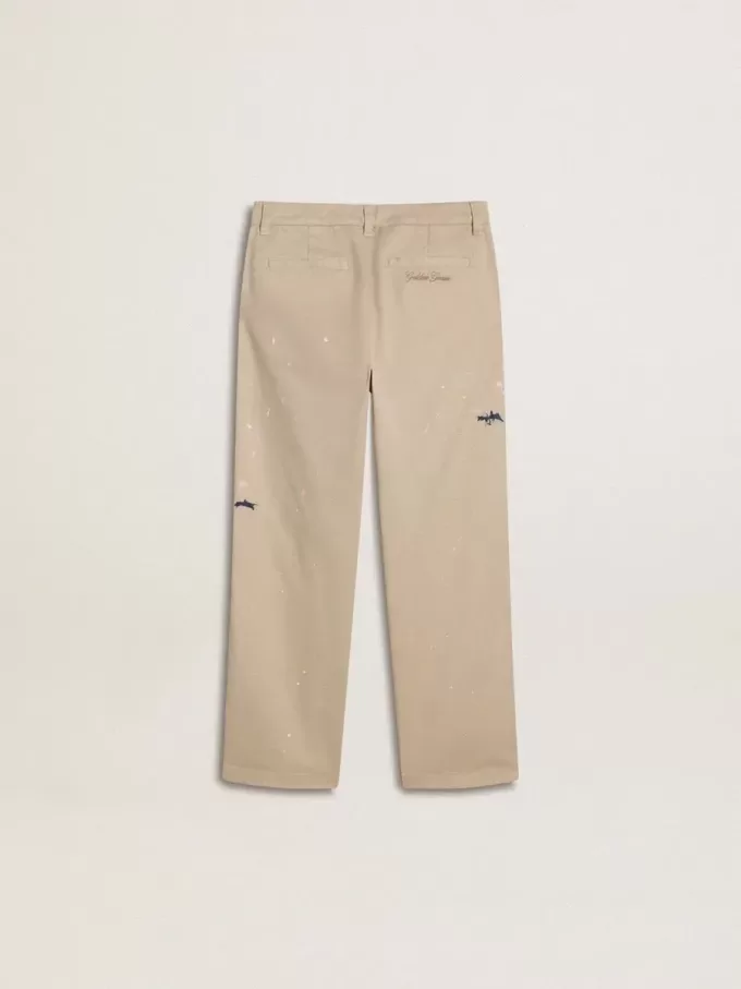 Pantalones chinos beige para niño con salpicaduras multicolores Pantalones chinos beige para niño con salpicaduras multicolores