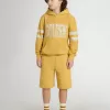 Pantalones cortos de jogging para niños en amarillo ocre con bordado Pantalones cortos de jogging para niños en amarillo ocre con bordado