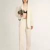 Pantalones holgados de mujer en tejido sastre blanco desgastado Pantalones holgados de mujer en tejido sastre blanco desgastado
