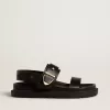 Sandalia Lucy para mujer en piel negra brillante con hebilla metálica dorada Sandalia Lucy para mujer en piel negra brillante con hebilla metálica dorada