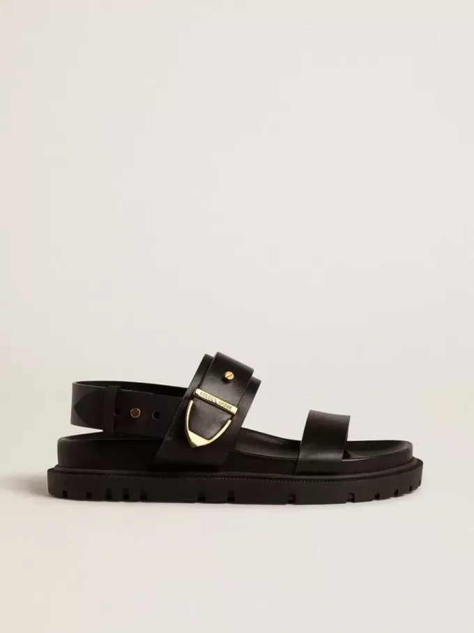 Sandalia Lucy para mujer en piel negra brillante con hebilla metálica dorada Sandalia Lucy para mujer en piel negra brillante con hebilla metálica dorada