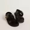 Sandalia Lucy para mujer en piel negra brillante con hebilla metálica dorada Sandalia Lucy para mujer en piel negra brillante con hebilla metálica dorada