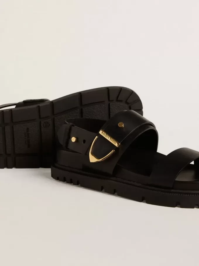 Sandalia Lucy para mujer en piel negra brillante con hebilla metálica dorada Sandalia Lucy para mujer en piel negra brillante con hebilla metálica dorada