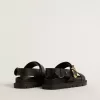 Sandalia Lucy para mujer en piel negra brillante con hebilla metálica dorada Sandalia Lucy para mujer en piel negra brillante con hebilla metálica dorada