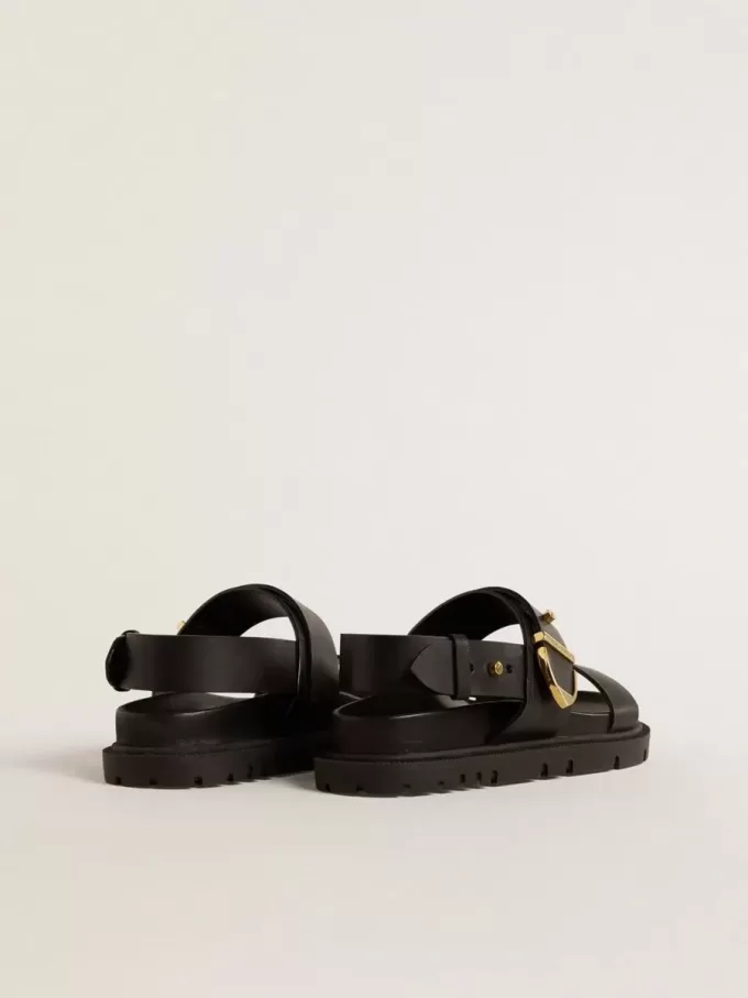 Sandalia Lucy para mujer en piel negra brillante con hebilla metálica dorada Sandalia Lucy para mujer en piel negra brillante con hebilla metálica dorada