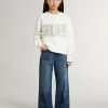Sudadera blanca para niña con inscripción multicolor «Golden» en la parte delantera Sudadera blanca para niña con inscripción multicolor «Golden» en la parte delantera