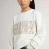 Sudadera blanca para niña con inscripción multicolor «Golden» en la parte delantera Sudadera blanca para niña con inscripción multicolor «Golden» en la parte delantera