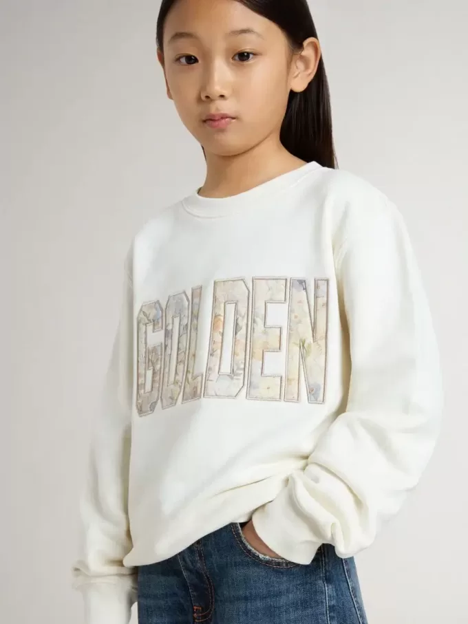 Sudadera blanca para niña con inscripción multicolor «Golden» en la parte delantera Sudadera blanca para niña con inscripción multicolor «Golden» en la parte delantera