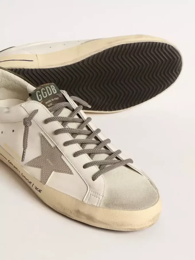 Super-Star LTD con estrella con estampado de cocodrilo y lengüeta verde en el talón. Super-Star LTD con estrella con estampado de cocodrilo y lengüeta verde en el talón.