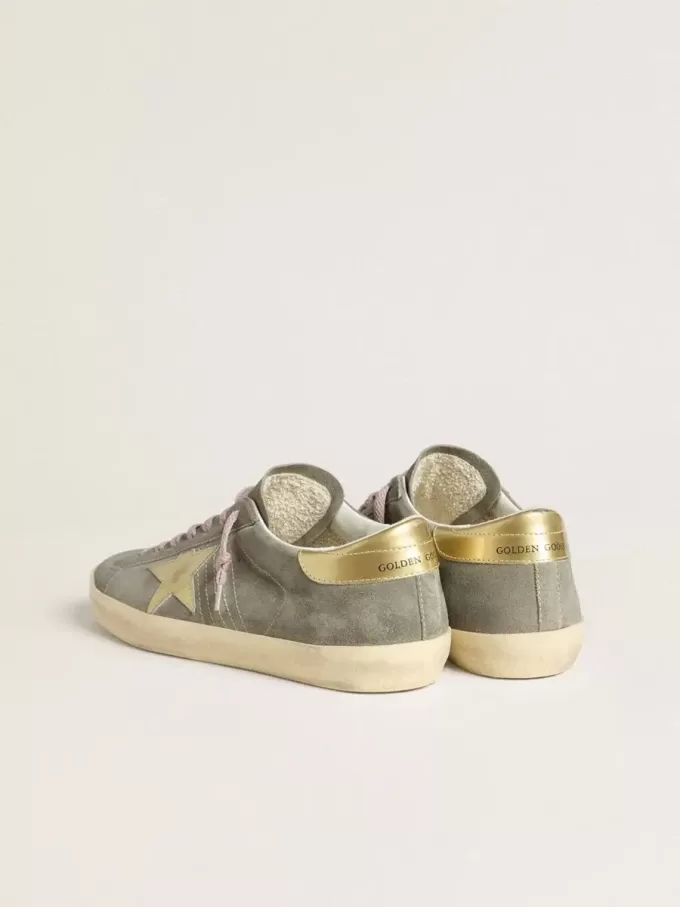 Super-Star para hombre en ante gris con estrella y lengüeta en el talón de cuero metalizado dorado Super-Star para hombre en ante gris con estrella y lengüeta en el talón de cuero metalizado dorado