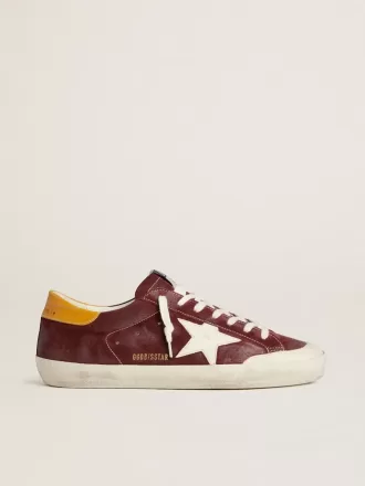Super-Star para hombre en ante rojo ladrillo con estrella de cuero blanco y lengüeta del talón con estampado animal. Super-Star para hombre en ante rojo ladrillo con estrella de cuero blanco y lengüeta del talón con estampado animal.