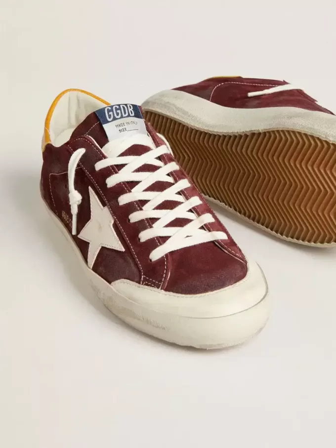Super-Star para hombre en ante rojo ladrillo con estrella de cuero blanco y lengüeta del talón con estampado animal.