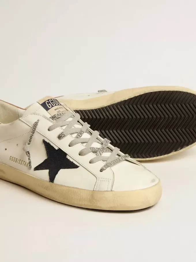 Super-Star para hombre en piel blanca con estrella de lona azul medianoche y lengüeta del talón en piel color tabaco. Super-Star para hombre en piel blanca con estrella de lona azul medianoche y lengüeta del talón en piel color tabaco.