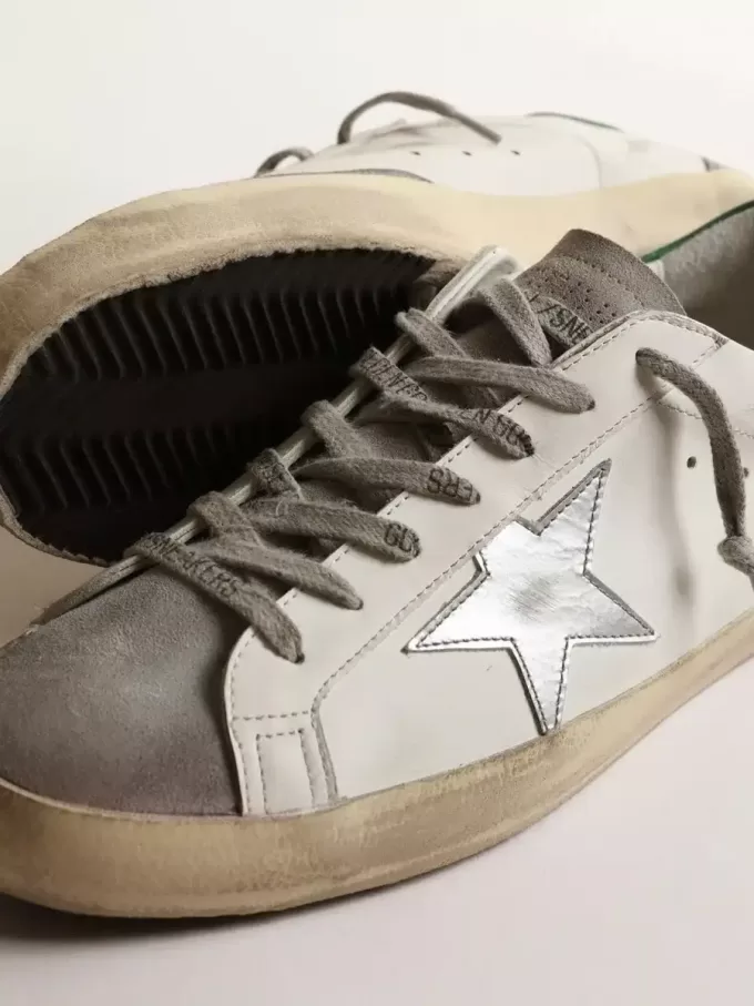 Super-Star para hombre en piel blanca con estrella plateada y lengüeta verde en el talón Super-Star para hombre en piel blanca con estrella plateada y lengüeta verde en el talón