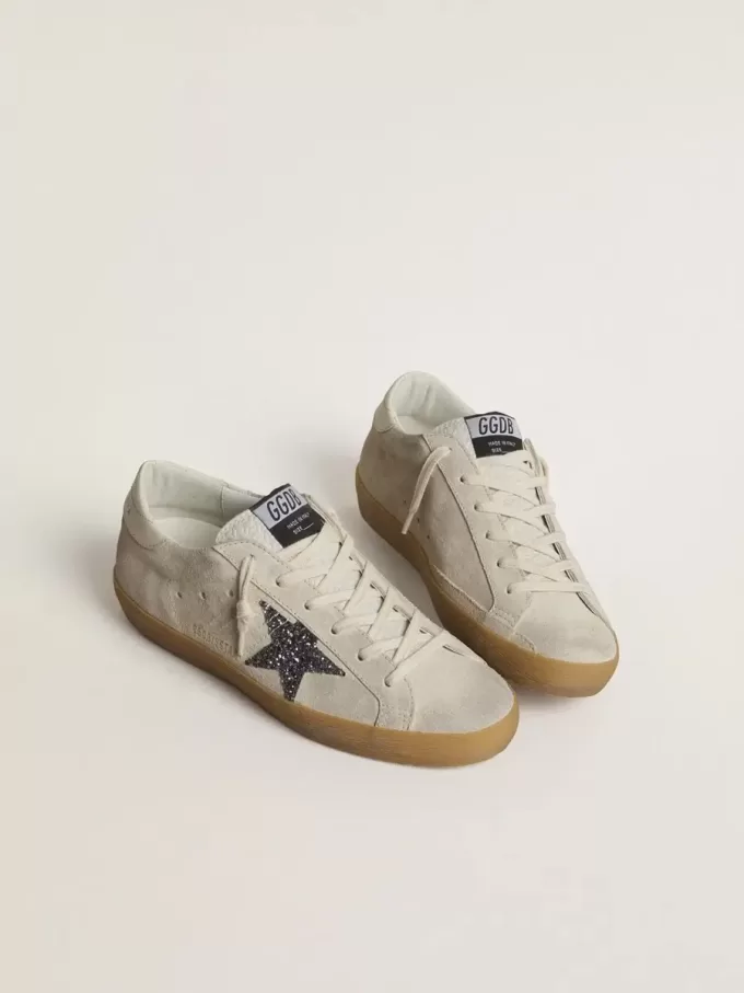 Super-Star para mujer en ante gris hielo con estrella plateada brillante y lengüeta de cuero en el talón. Super-Star para mujer en ante gris hielo con estrella plateada brillante y lengüeta de cuero en el talón.