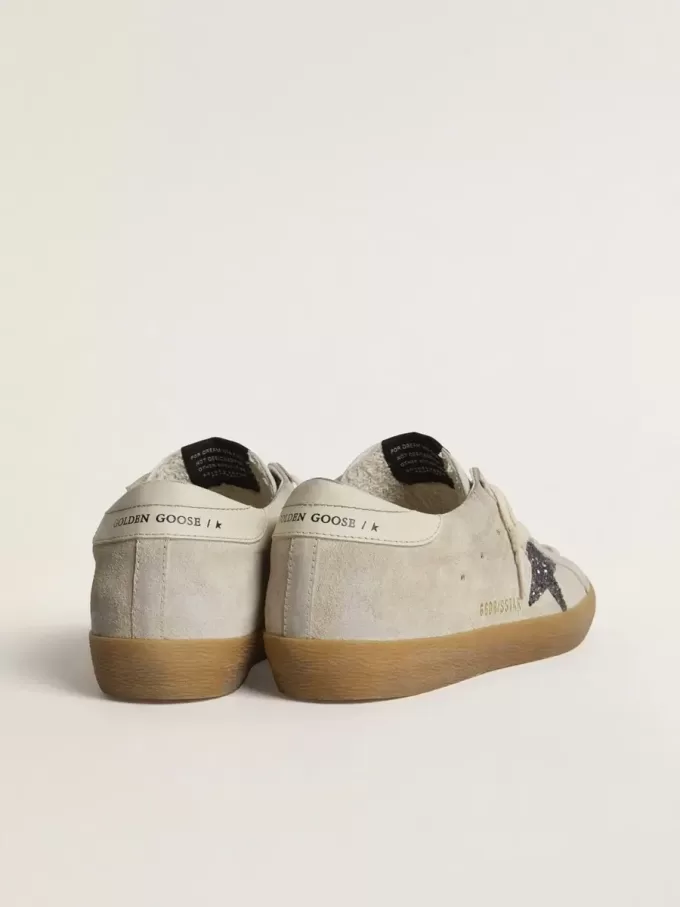 Super-Star para mujer en ante gris hielo con estrella plateada brillante y lengüeta de cuero en el talón. Super-Star para mujer en ante gris hielo con estrella plateada brillante y lengüeta de cuero en el talón.