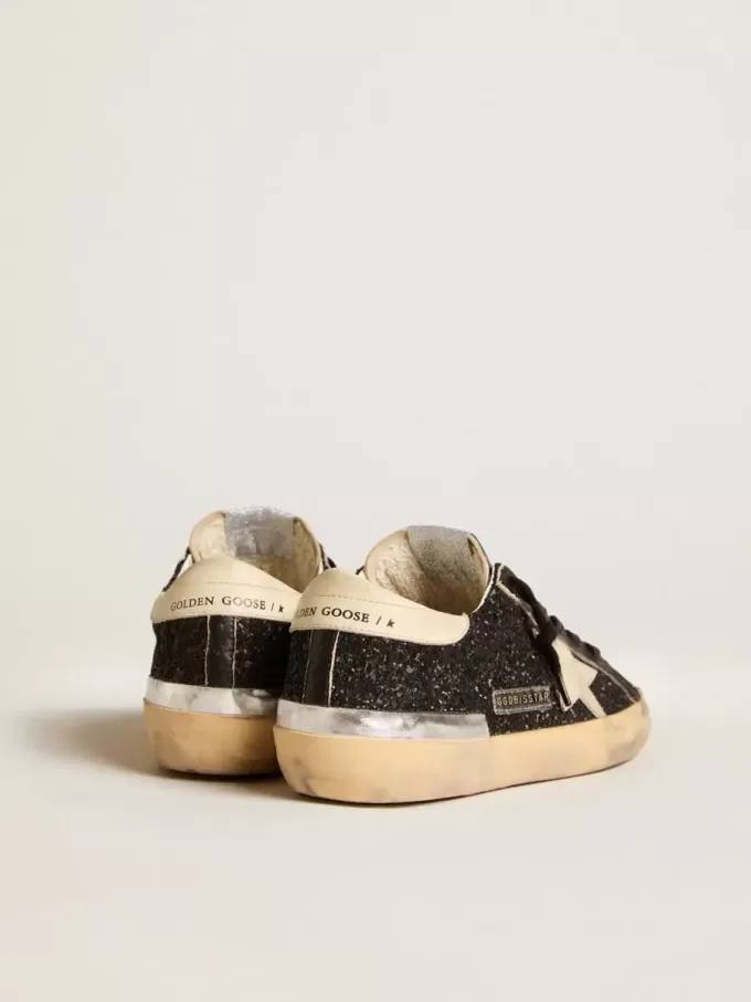 Super-Star para mujer en negro brillante y napa con estrella y lengüeta del talón en piel color crema. Super-Star para mujer en negro brillante y napa con estrella y lengüeta del talón en piel color crema.