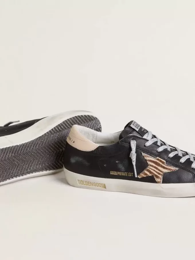 Super-Star para mujer en piel napa negra con estrella de piel de potro con estampado de cebra y lengüeta del talón en piel beige. Super-Star para mujer en piel napa negra con estrella de piel de potro con estampado de cebra y lengüeta del talón en piel beige.