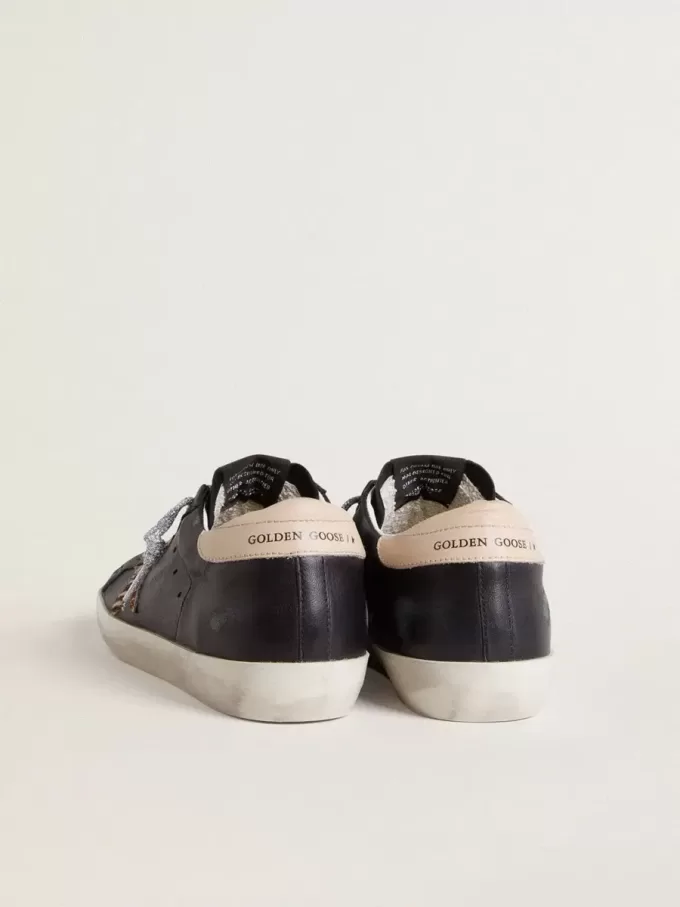 Super-Star para mujer en piel napa negra con estrella de piel de potro con estampado de cebra y lengüeta del talón en piel beige. Super-Star para mujer en piel napa negra con estrella de piel de potro con estampado de cebra y lengüeta del talón en piel beige.